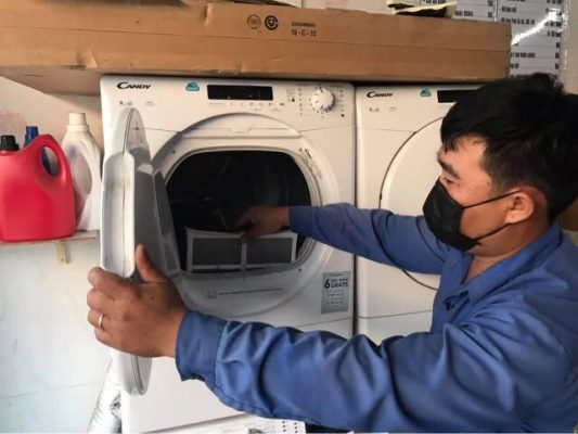 Kỹ thuật viên kiểm tra lưới lọc máy sấy quần áo tại nhà